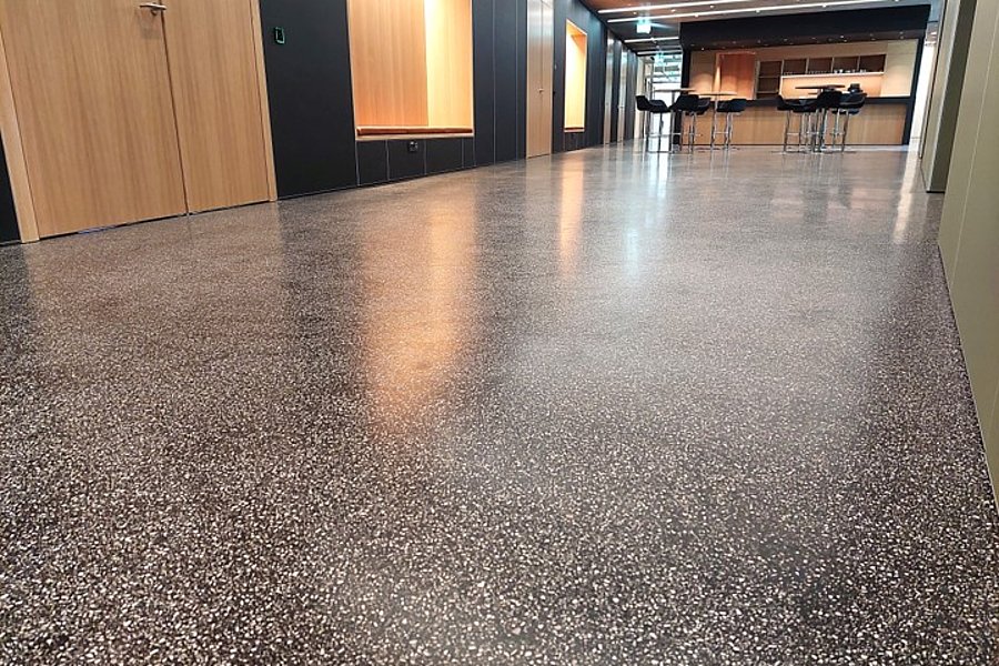 Geschliffener Gussasphalt im BituTerrazzo Verfahren, fugenlos als hochwertiger und langlebiger Bodenbelag im modernen Innenbereich.