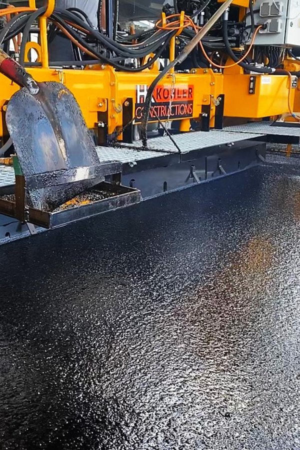 Fachgerechter Einbau einer langlebigen Gussasphaltdeckschicht mit einer Gussasphalt-Bohle im Parking P+R Stade de Luxembourg.