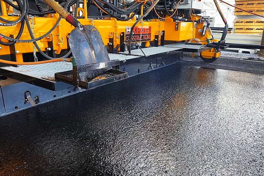 Fachgerechter Einbau einer langlebigen Gussasphaltdeckschicht mit einer Gussasphalt-Bohle im Parking P+R Stade de Luxembourg.