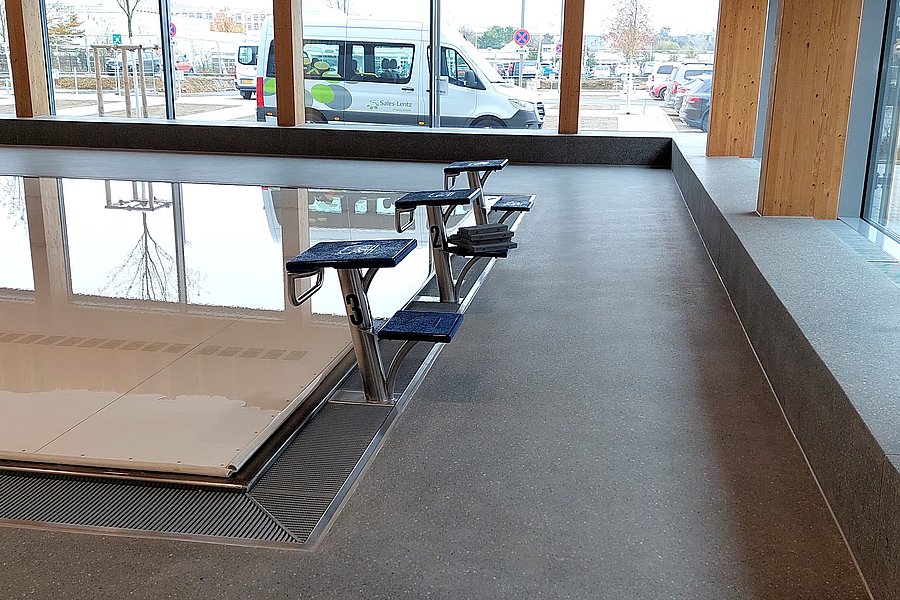 Geschliffener Gussasphalt BituTerrazzo als langlebiger Bodenbelag im Außenbereich eines öffentlichen Schwimmbads.