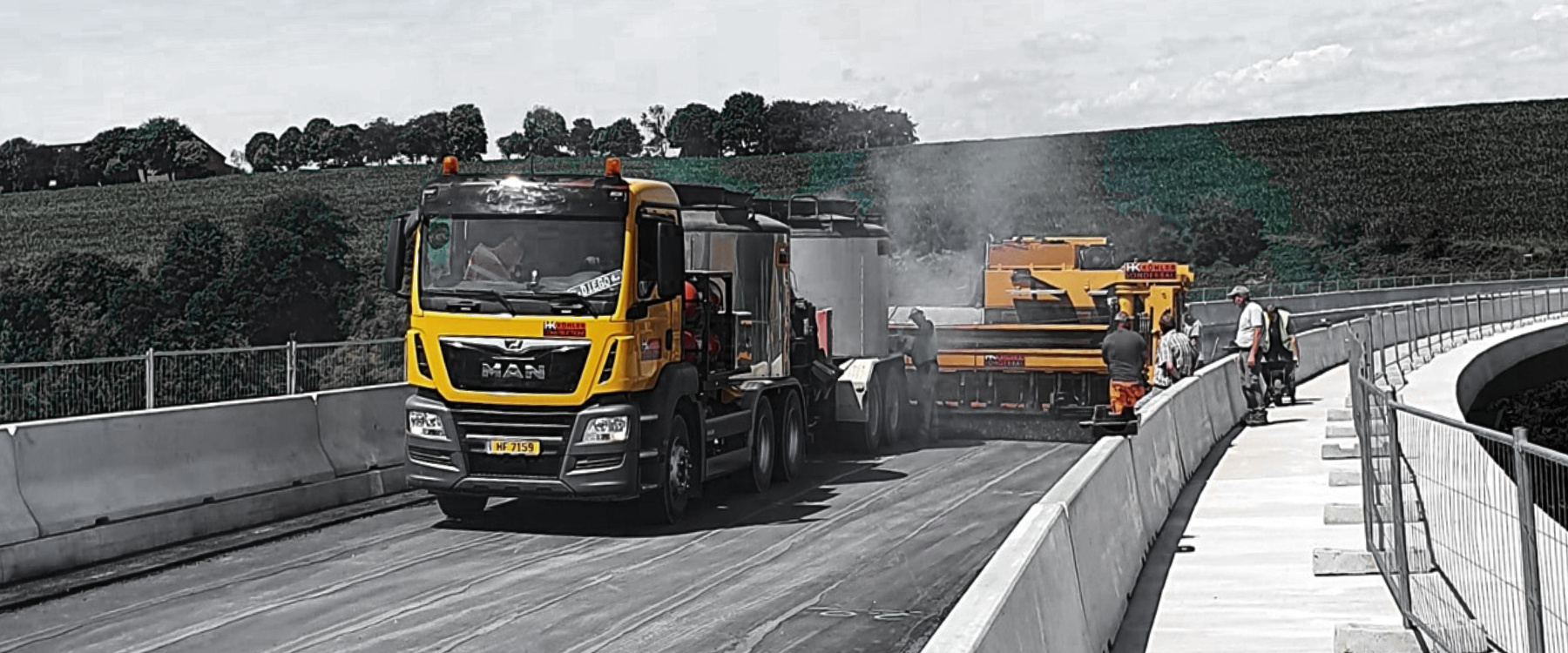 Fachgerechter Einbau einer langlebigen Gussasphaltdeckschicht mit einer Gussasphalt-Bohle auf einer Brücke.